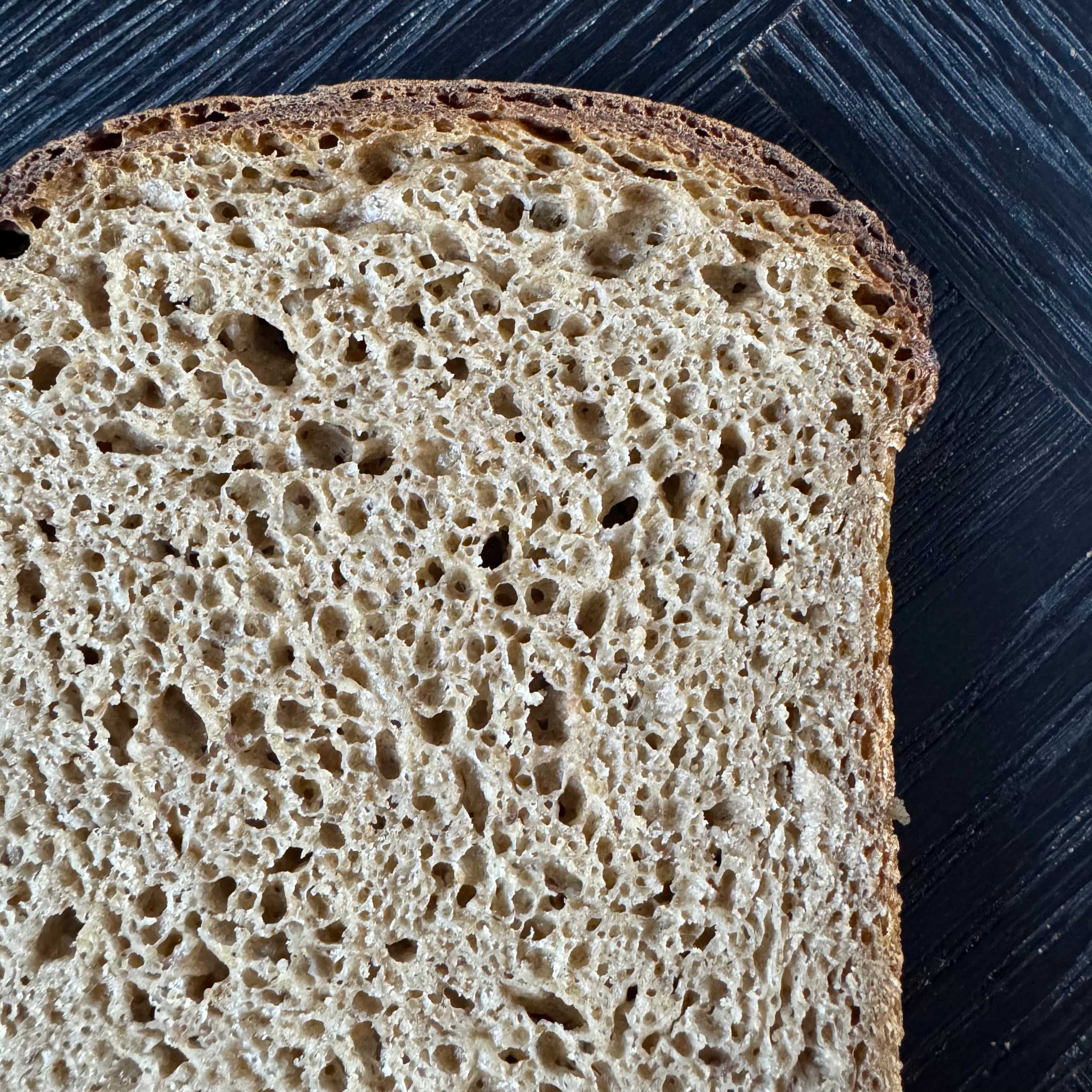 Detailaufnahme von Jochen Gaues Gersterbrot mit rustikaler Porung und saftiger Krume, handwerklich gebacken