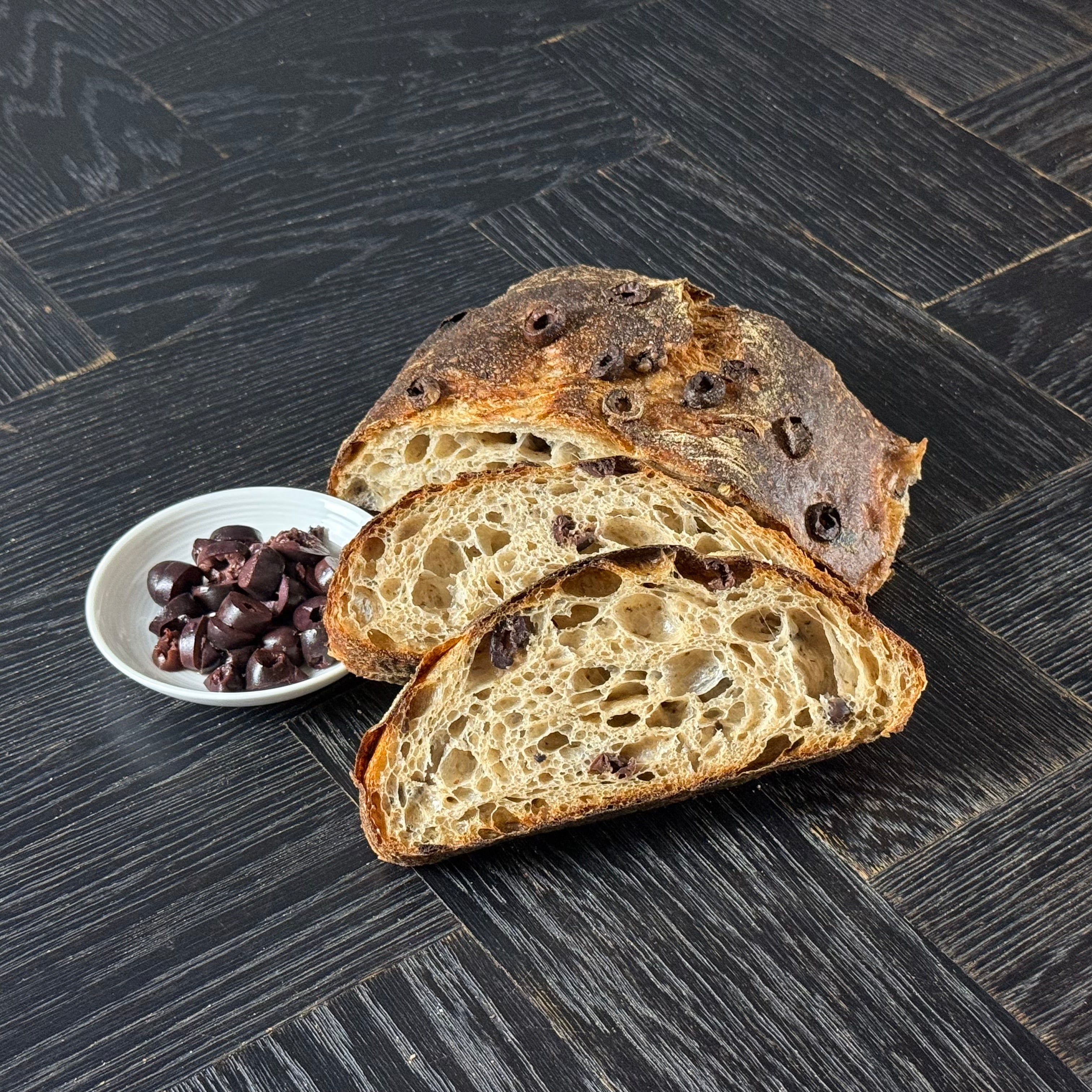Aufgeschnittenes Oliven Ciabatta mit luftiger Krume und eingebackenen Oliven von Jochen Gaues
