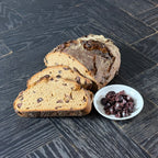 Aufgeschnittenes Gaues Oxbrot mit luftiger Krume und sichtbaren Kalamata Oliven im Teig